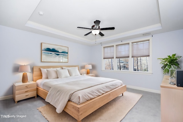 carpeted bedroom with visible vents, baseboards, a raised ceiling, a ceiling fan, and ornamental molding