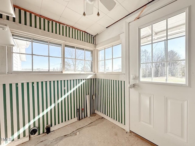 unfurnished sunroom with ceiling fan and a wealth of natural light