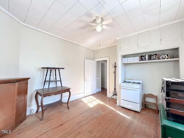 interior space with wood-type flooring, ceiling fan, and ornamental molding