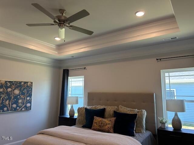 bedroom with a tray ceiling, ceiling fan, and crown molding