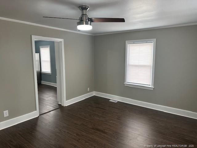 1016 E 8th St, Lumberton, NC 28358 - unfurnished room with crown molding, a healthy amount of sunlight, and dark hardwood / wood-style flooring