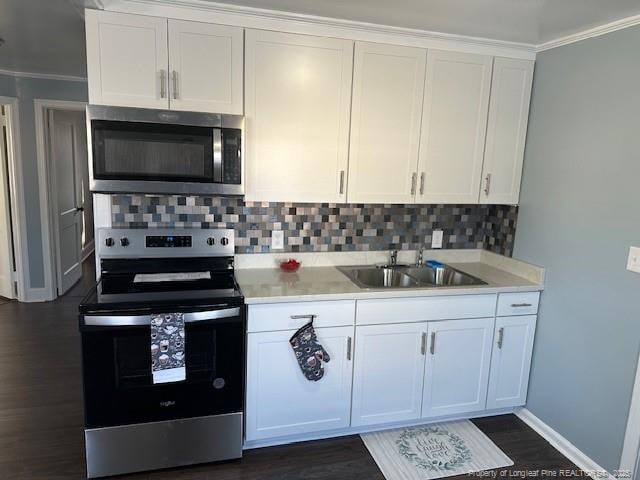 1016 E 8th St, Lumberton, NC 28358 - kitchen featuring sink, dark wood-type flooring, appliances with stainless steel finishes, white cabinetry, and tasteful backsplash