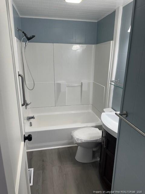 1016 E 8th St, Lumberton, NC 28358 - full bathroom featuring vanity, toilet, hardwood / wood-style floors, and shower / bathing tub combination
