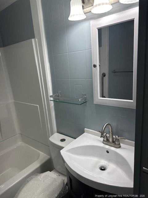 1016 E 8th St, Lumberton, NC 28358 - full bathroom with tile walls, sink, tub / shower combination, and toilet
