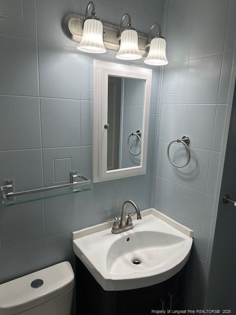1016 E 8th St, Lumberton, NC 28358 - bathroom featuring toilet, sink, and tile walls