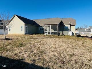 back of house featuring a yard and a sunroom