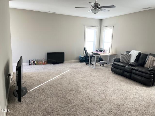 living room featuring carpet and ceiling fan