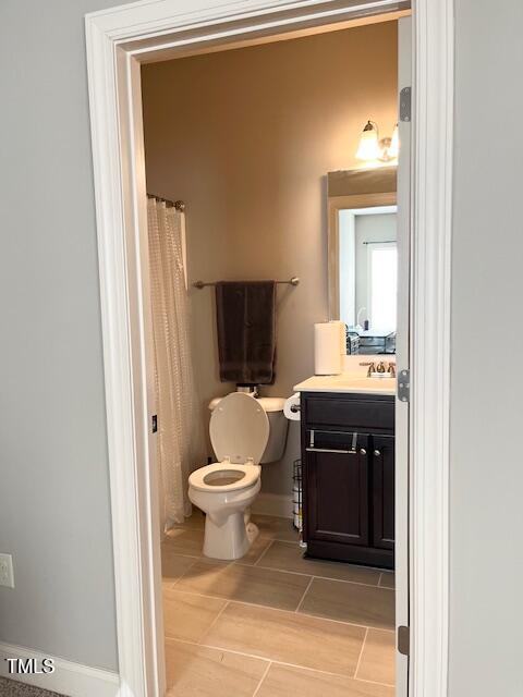 bathroom featuring a shower with shower curtain, vanity, and toilet