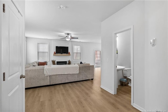 living room featuring light hardwood / wood-style floors and ceiling fan