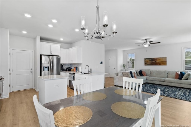 dining area featuring sink, light hardwood / wood-style flooring, and ceiling fan