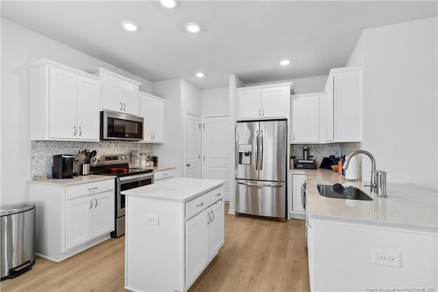 kitchen featuring appliances with stainless steel finishes, sink, white cabinets, and kitchen peninsula