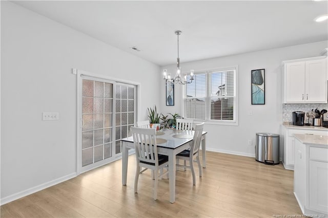 dining room with an inviting chandelier and light wood-type flooring