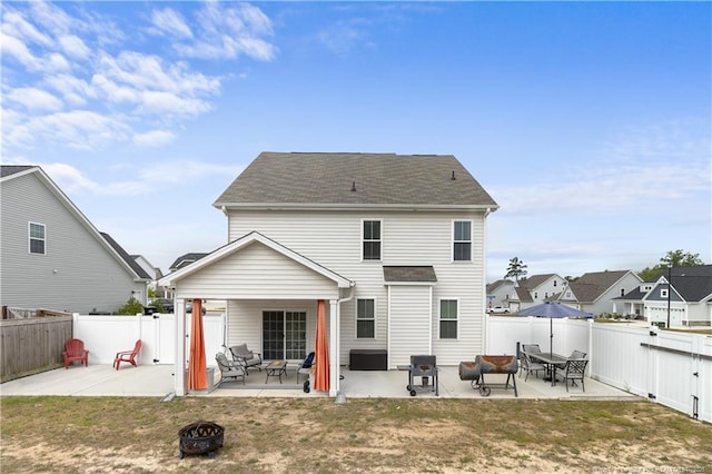 back of property featuring an outdoor fire pit, a yard, and a patio area