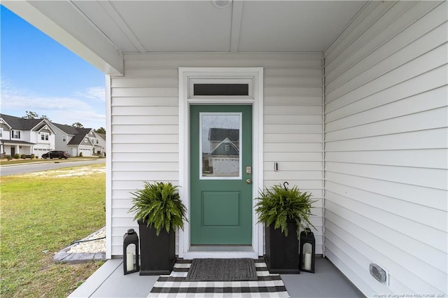 doorway to property featuring a yard and a residential view