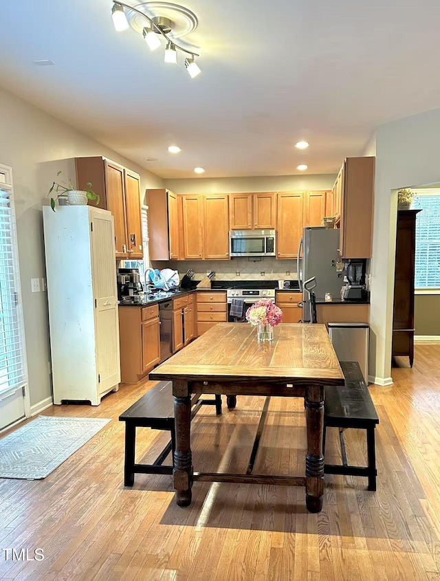 kitchen featuring appliances with stainless steel finishes, sink, and light wood-type flooring