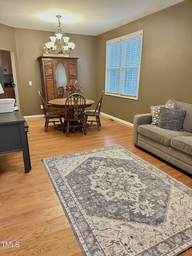 dining space with a notable chandelier and hardwood / wood-style flooring