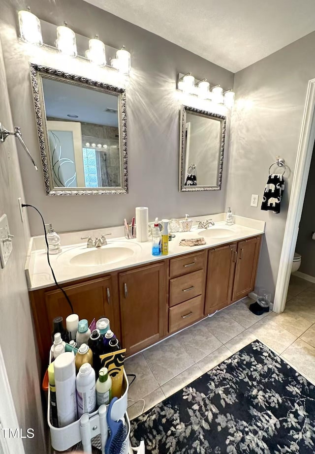 bathroom featuring vanity, toilet, and tile patterned flooring