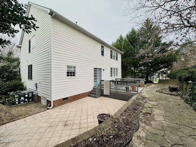 back of property featuring a deck and a patio area