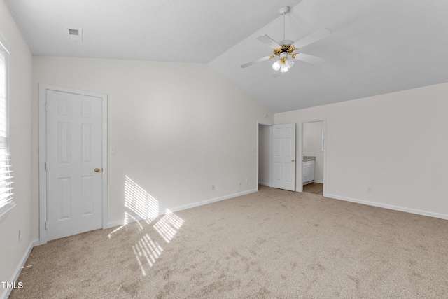 unfurnished bedroom with lofted ceiling, carpet, visible vents, and baseboards