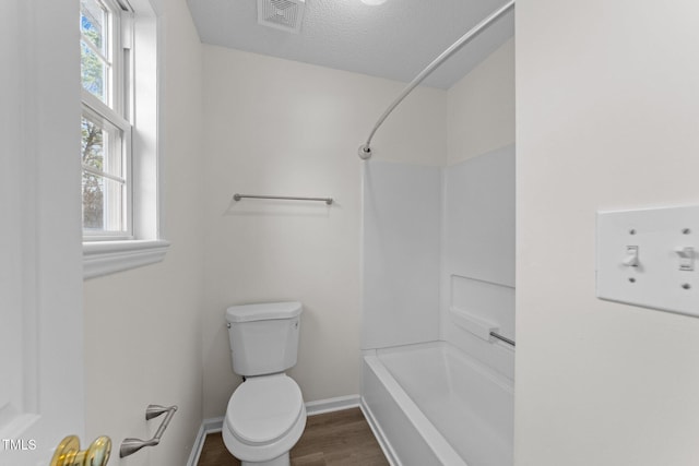 bathroom with visible vents, toilet, a textured ceiling, wood finished floors, and baseboards