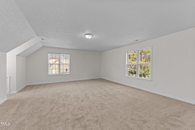 bonus room with carpet floors, baseboards, visible vents, and a textured ceiling