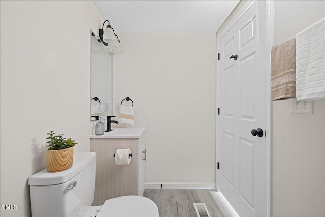 bathroom with vanity, hardwood / wood-style flooring, and toilet