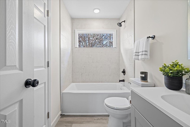 full bathroom with hardwood / wood-style floors, vanity, toilet, and tiled shower / bath combo