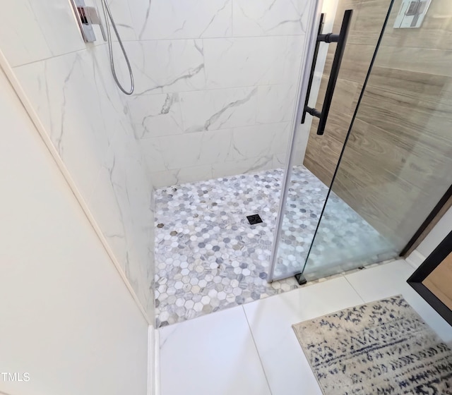 bathroom featuring tile patterned floors and a tile shower