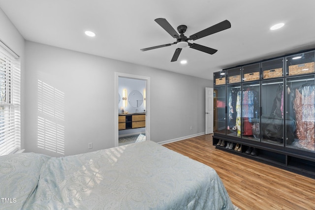 bedroom with ceiling fan, multiple windows, and hardwood / wood-style floors