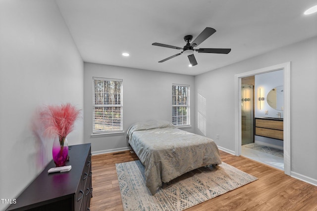 bedroom with ceiling fan, ensuite bathroom, hardwood / wood-style floors, and sink