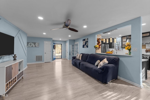 living room featuring ceiling fan and light wood-type flooring