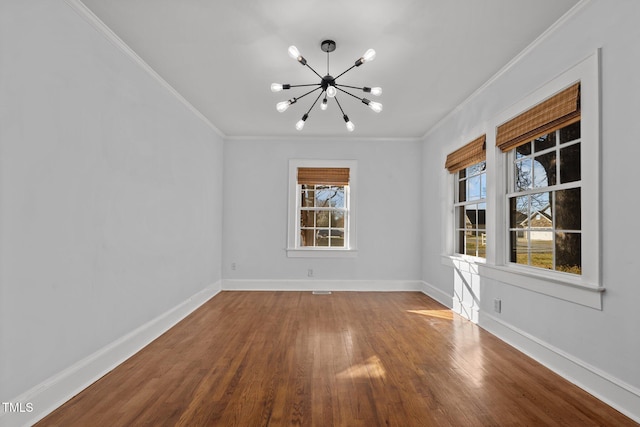 unfurnished room featuring crown molding, hardwood / wood-style floors, and a chandelier