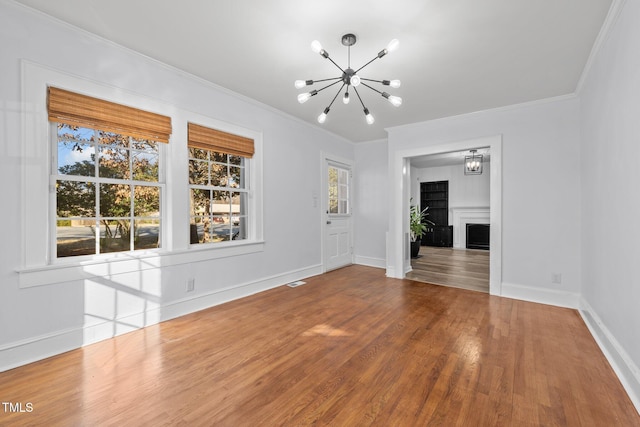 interior space with hardwood / wood-style flooring, crown molding, and a chandelier