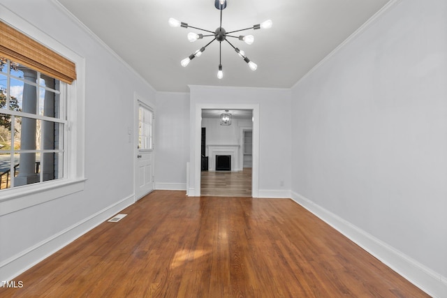 unfurnished living room featuring ornamental molding, a chandelier, and wood-type flooring