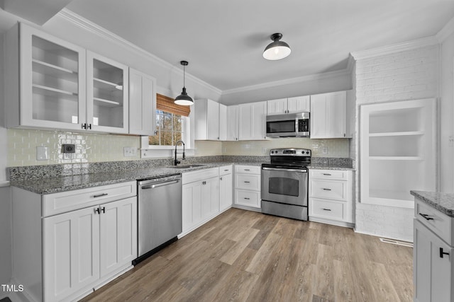 kitchen with white cabinets, pendant lighting, sink, and appliances with stainless steel finishes