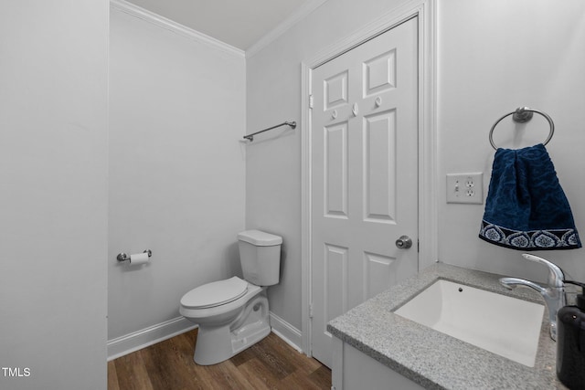 bathroom with vanity, toilet, ornamental molding, and wood-type flooring