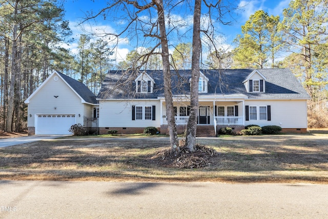 cape cod house with covered porch, a garage, and a front lawn