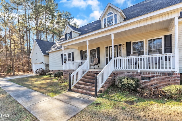 view of front of home with covered porch, an outbuilding, and a garage