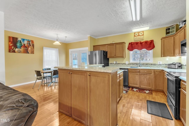 kitchen featuring a center island, crown molding, a textured ceiling, appliances with stainless steel finishes, and light hardwood / wood-style floors