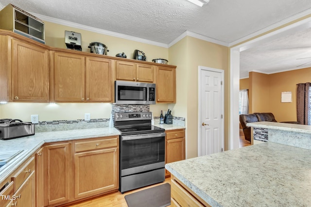 kitchen featuring decorative backsplash, light wood-type flooring, a textured ceiling, stainless steel appliances, and crown molding