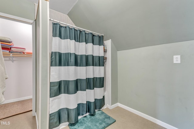 bathroom featuring walk in shower and vaulted ceiling