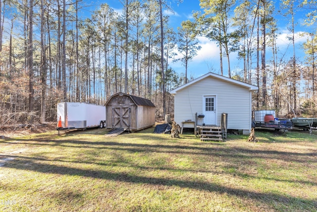 back of house featuring a lawn and a storage shed