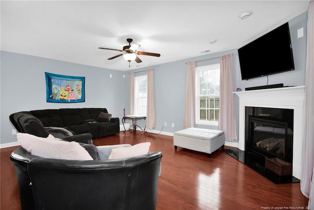 living room with ceiling fan and dark wood-type flooring