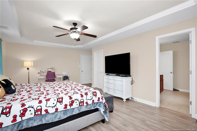 bedroom with a tray ceiling, light hardwood / wood-style flooring, ceiling fan, and ornamental molding