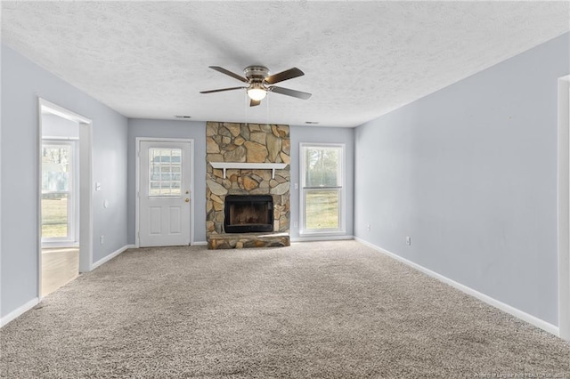 unfurnished living room featuring a fireplace, a textured ceiling, carpet flooring, and ceiling fan