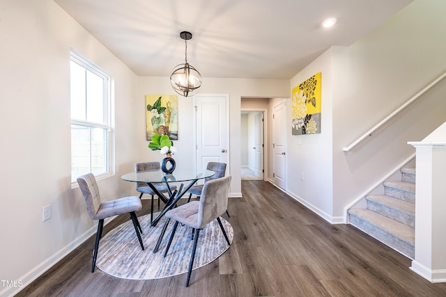 dining space with dark hardwood / wood-style flooring and an inviting chandelier