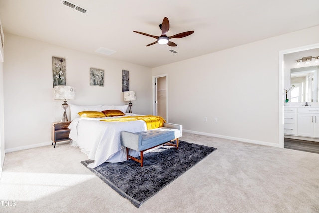 carpeted bedroom featuring ceiling fan, sink, connected bathroom, and a closet