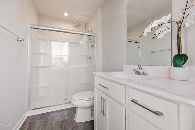 bathroom with vanity, hardwood / wood-style flooring, toilet, and walk in shower