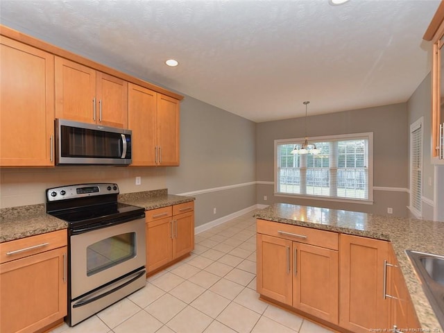 kitchen featuring appliances with stainless steel finishes, light brown cabinets, pendant lighting, an inviting chandelier, and light tile patterned flooring