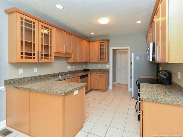 kitchen featuring backsplash, sink, light tile patterned flooring, kitchen peninsula, and stainless steel appliances